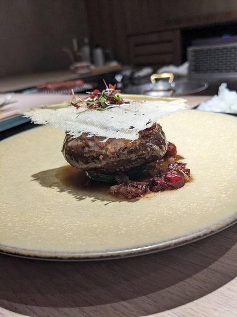 Wagyu and shiitake mushroom with a slice of grilled parmesan cheese on top
